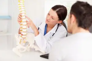 chiropractor in Fort Wayne showing a model of the spine to a patient in