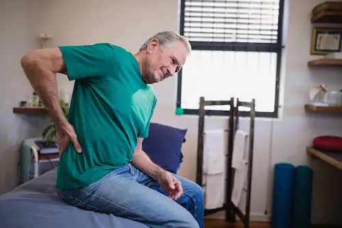 elderly man holding his hip