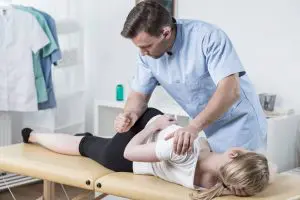 Chiropractor giving flexion distraction therapy to the patient.