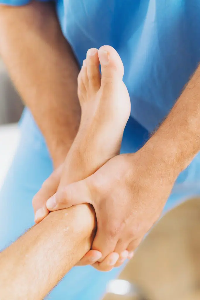 chiropractor adjusting patients ankle and foot | ankle pain treatment in fort wayne