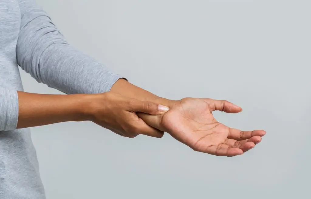 female patient holding her wrist due to pain