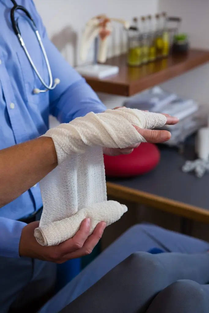 doctor wrapping a patients wrist with a bandage 