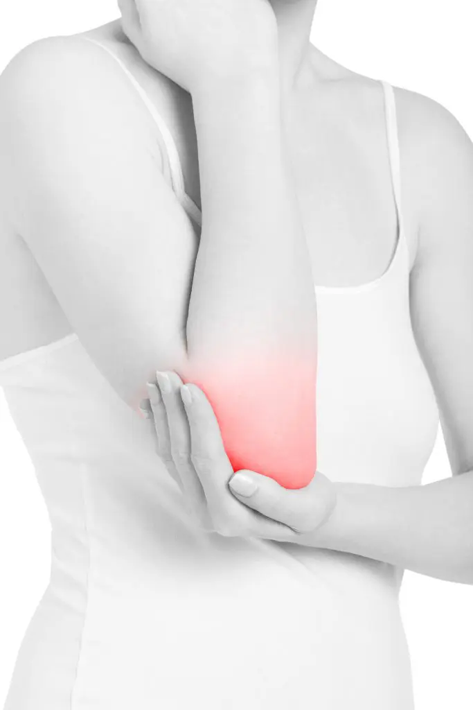 woman holding her elbow due to inflammation pain | elbow pain treatment in fort wayne