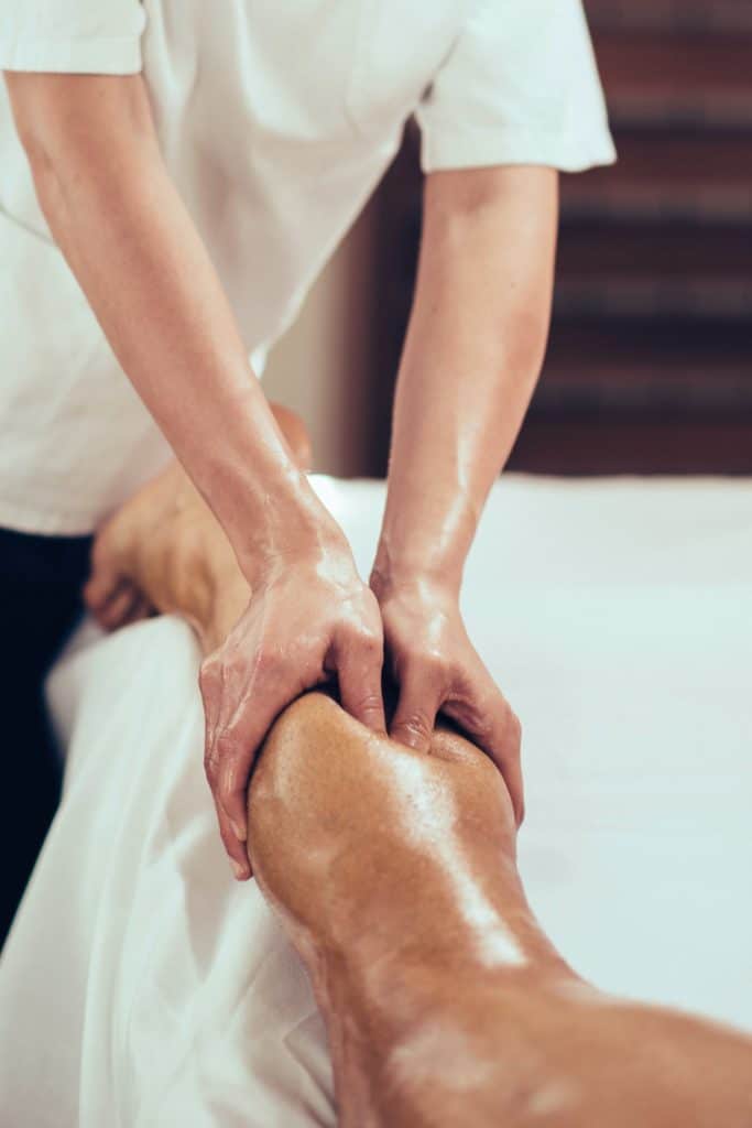 massage therapist massaging patient calf 