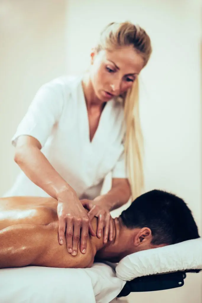 massage therapist massaging patients neck 