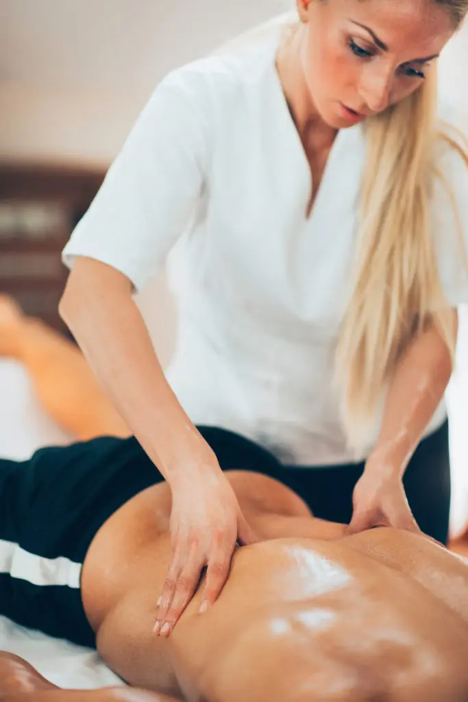 massage therapist massaging patient lower back 