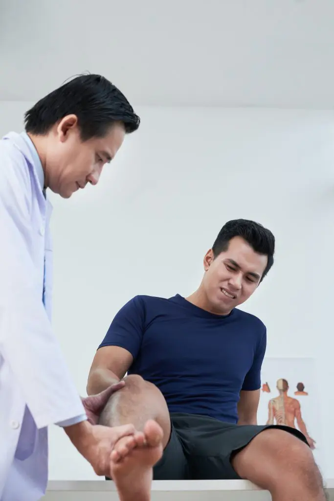 chiropractor examining patient knee