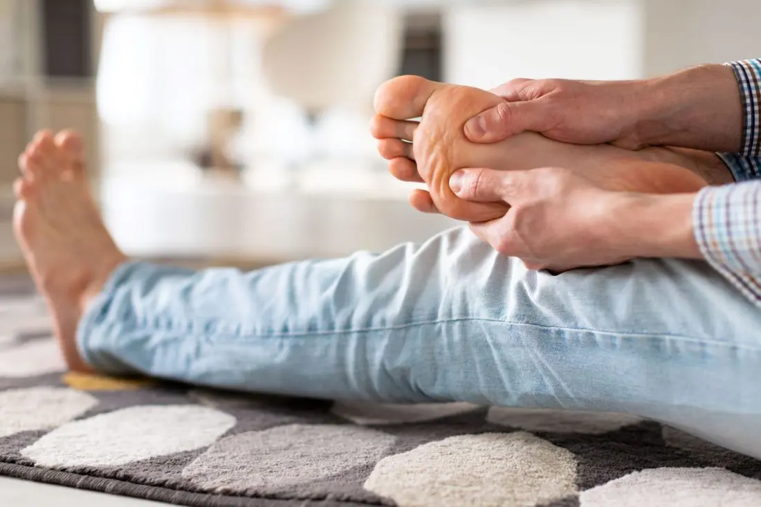 Man massaging his foot due to pain 