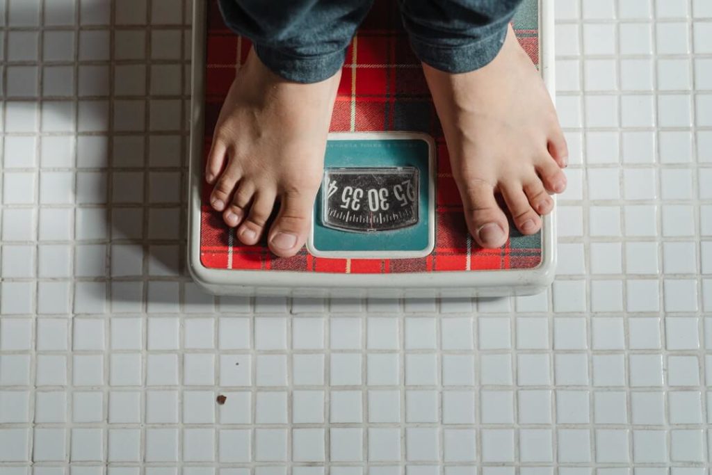 man on a weighing scale - weight loss concept