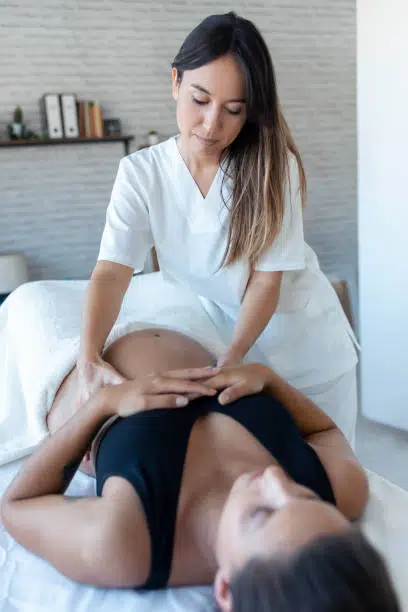 Pregnant woman is having a prenatal massage in a chiropractic clinic