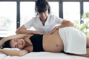 Pregnant woman is having a prenatal massage in a chiropractic clinic