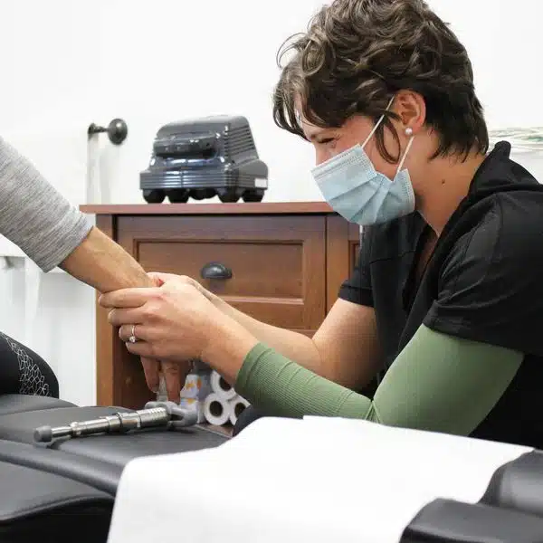 Chiropractor is checking a patients hand.