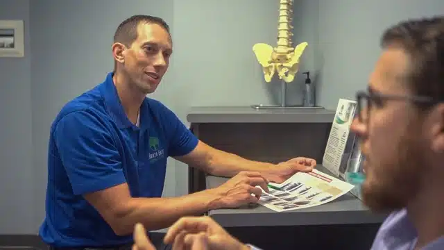 Chiropractor is having a consultation with a patient at North East Chiropractic Center.