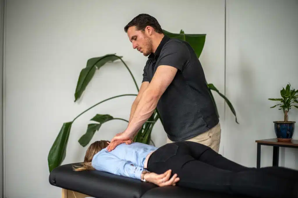 chiropractor adjusting a young woman's back.