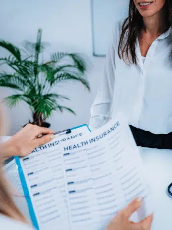 Chiropractor explaining the health insurance coverage to the patient.