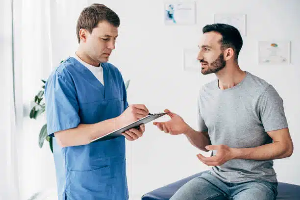 Chiropractor explaining the health insurance coverage to the patient before the treatment.