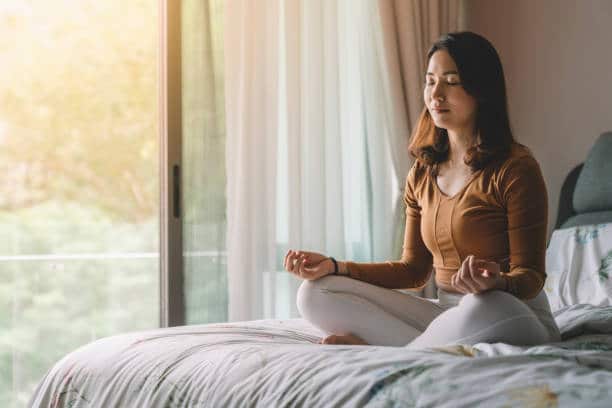 Woman doing some yoga at home to improve mental health. 