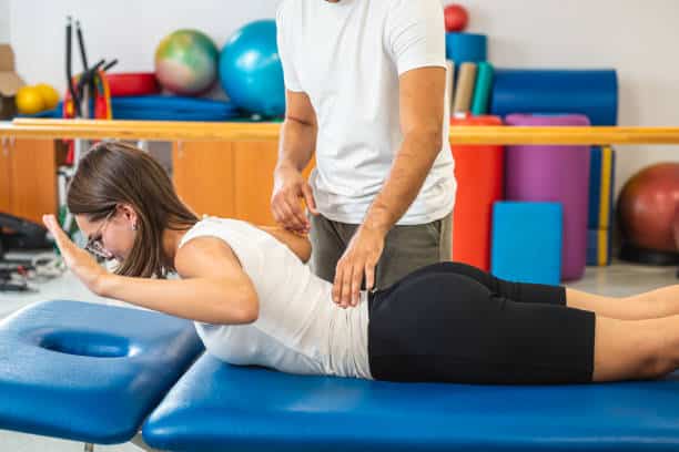 Chiropractor helping a patient to do some Corrective exercises.