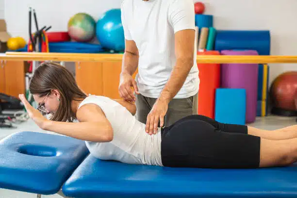 Chiropractor helping a patient to do some Corrective exercises.