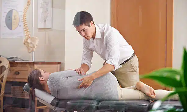 chiropractor adjusting a young woman's spine