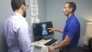Dr. Adam Osenga discussing an xray results of spine with a patient.