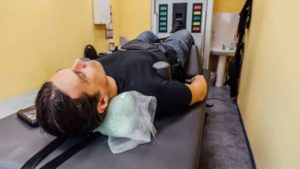Man at non-surgical spinal decompression procedure in a medical center.