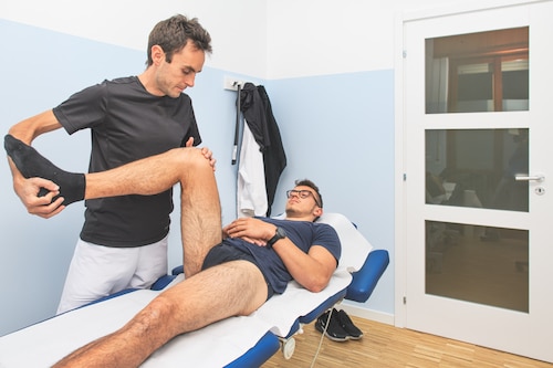 chiropractor performs exercises as assessment for sports injury
