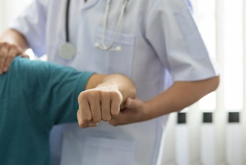 Experienced Specialists in Shoulder Pain Management doing assessment on patient's arm for shoulder pain treatment in fort wayne