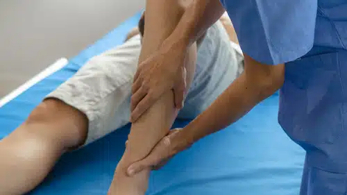 chiropractor making initial assessment with patients leg after personal injury treatment in Fort Wayne
