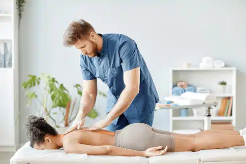 experienced chiropractor treating female patient with back pain for personal injury treatment in Fort Wayne