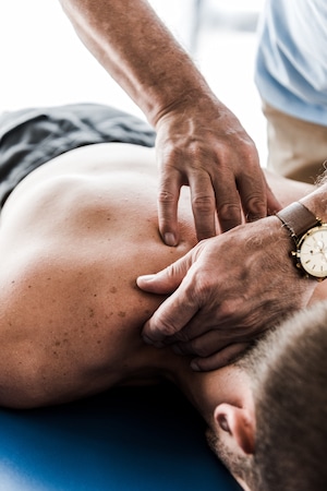 chiropractor massaging patients back for myofascial pain treatment in Fort Wayne