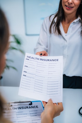 health insurance claim form handed to patient for insured and covered chiropractic care therapy