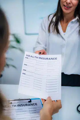 health insurance claim form handed to patient for insured and covered chiropractic care therapy