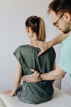 chiropractor examining patients back to correct posture for the common posture problems