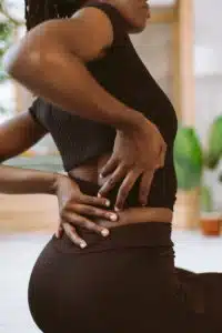 back view of a female patient experiencing acute back pain | acute vs chronic back pain
