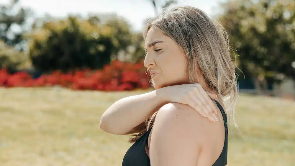 woman holding her shoulder due to severe pain