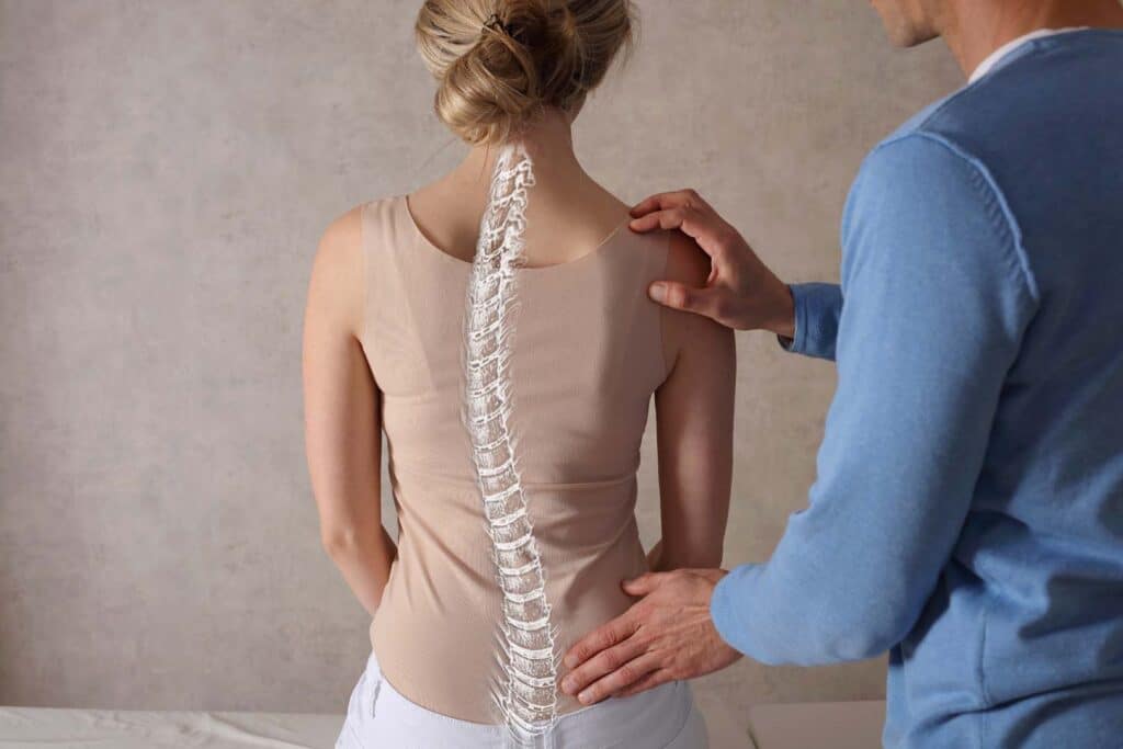 Chiropractor evaluating spinal alignment to support back pain treatment